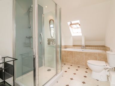 A bathroom with a shower cubicle bathtub toilet and a window at Barleside in Dulverton