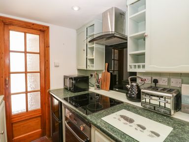 A kitchen with a stove microwave kettle and toaster on the counter at Steel Works Farm in Gorsley