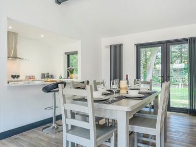 A dining area featuring a table with chairs and a bar stool at The Cottage in Wimborne Minster