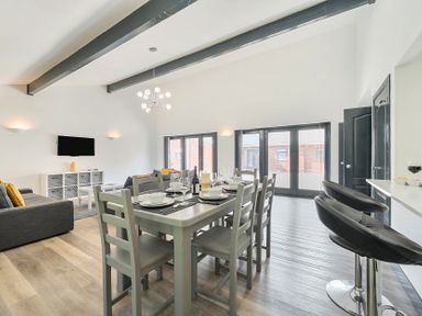 A living room with dining area and sofa at The Cottage in Wimborne Minster