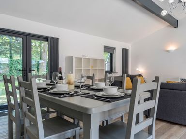 A dining room with a table set for dinner at The Cottage in Wimborne Minster