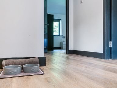 A hallway with dog bowls placed on a mat at The Cottage in Wimborne Minster