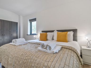 A bedroom with a bed and wardrobe at The Cottage in Wimborne Minster