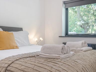 A bedroom with a bed and towels on the blanket at The Cottage in Wimborne Minster