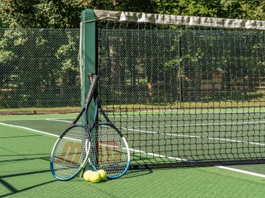 Tennis rackets and balls on a tennis court at The Cottage in Wimborne Minster