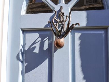 A blue wooden door with a metal octopus door knocker and an anchor decoration at Navigators Rest in Whitby