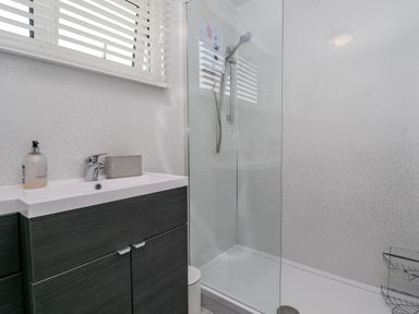 A bathroom with a sink cabinet and a walk-in shower at 19 Cherry Park in Chapel St Leonards