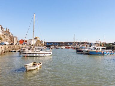 A harbor with boats docked on the water and buildings along the shore at Sea View Mevagissey