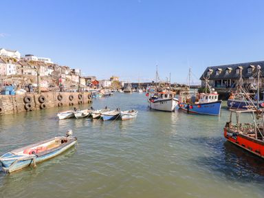 A harbor with fishing boats and houses on a hill at Sea View in Mevagissey
