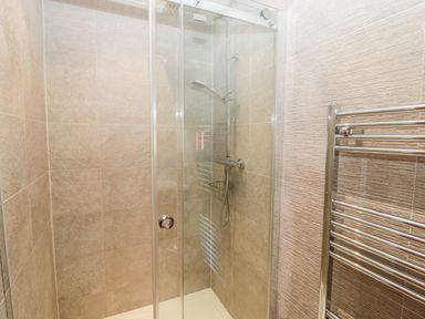 A shower area with glass doors and chrome fixtures at Lodge 32 in Otterburn