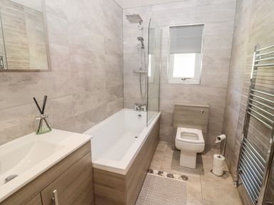 A bathroom with a bathtub shower toilet sink and towel radiator at Lodge 32 in Otterburn