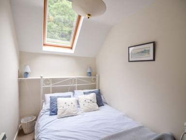 A bedroom with a bed pillows and a skylight window at 52 Fernhill Heights in Charmouth