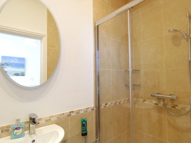 A bathroom with a shower and sink at 11 Cove View Apartments in Ilfracombe