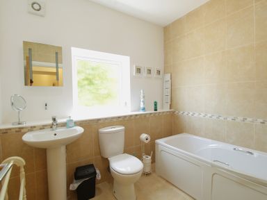 A bathroom with a sink, toilet, and bath at 11 Cove View Apartments in Ilfracombe