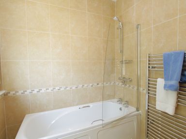 A bathroom with a bathtub and shower fixtures at 11 Cove View Apartments Ilfracombe