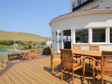 An outdoor seating area with wooden furniture at 11 Cove View Apartments in Ilfracombe