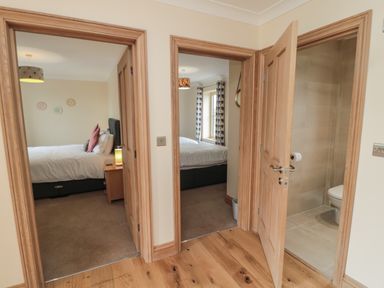 A hallway with doors leading to two bedrooms and a bathroom at Whinny Cottage in Embleton