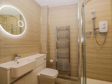 A bathroom with a sink toilet heated towel rail and shower at White Roses in Whitchurch near Monmouth