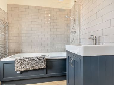 A bathroom with a bathtub and a sink with cabinet at The Paddock in Honington near Shipston-On-Stour
