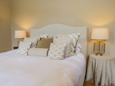 A bed with multiple pillows and two bedside tables with lamps at The Residence in Cleator