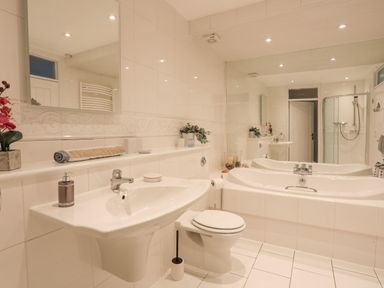 A bathroom with a sink toilet bathtub and shower at White Sails in Y Felinheli