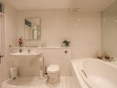 A bathroom with a bathtub a toilet and a sink at White Sails in Y Felinheli