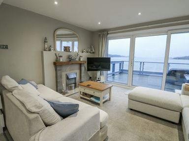 A living room with a sofa and television at White Sails Y Felinheli