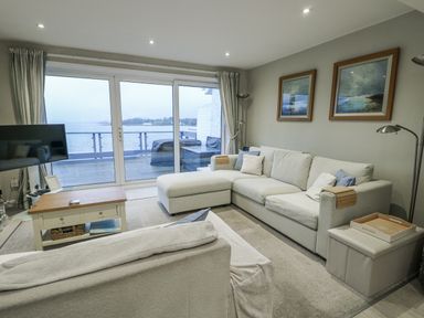 A living room with a sofa and television at White Sails Y Felinheli