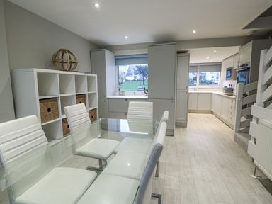A kitchen with a dining table and chairs at White Sails in Y Felinheli