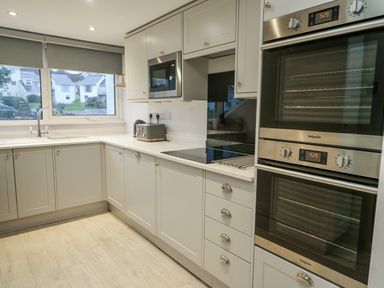 A kitchen with cabinets and appliances at White Sails in Y Felinheli