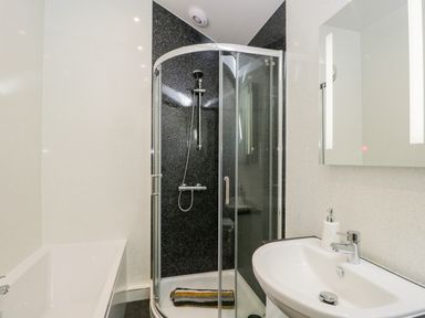 A bathroom with a shower enclosure bathtub and sink at Little Barn in Grange-Over-Sands near Cartmel