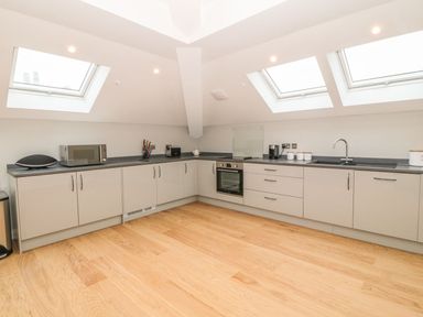 A kitchen with cabinets countertop microwave oven and skylight windows at Sardis Chapel 1 in Malltraeth