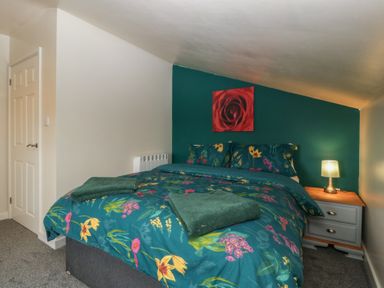 A bedroom with a bed, nightstand, and towels at Top Lodge in Llanvair-Discoed near Penhow