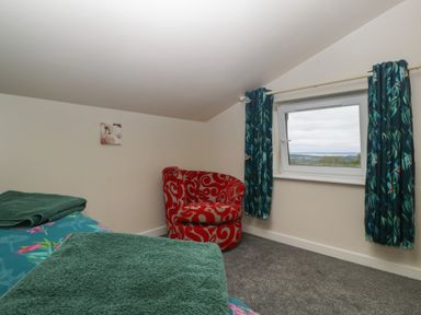 A bedroom with a bed and chair at Top Lodge in Llanvair-Discoed near Penhow