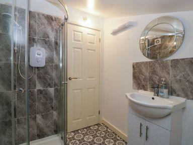 A bathroom with a shower and sink at Top Lodge Llanvair-Discoed near Penhow