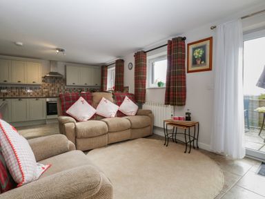 A living room with a sofa and kitchen units at Top Lodge in Llanvair-Discoed near Penhow
