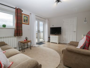 A living room with a TV and sofa at Top Lodge in Llanvair-Discoed near Penhow