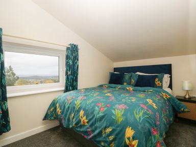 A bedroom with a bed and a window at Top Lodge in Llanvair-Discoed near Penhow