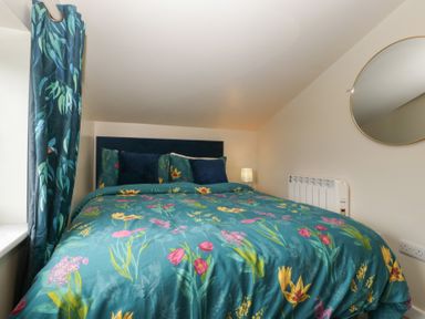 A bedroom with a bed and curtains at Top Lodge in Llanvair-Discoed near Penhow