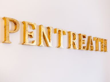 Golden letters spelling PENTREATH mounted on a white wall at Pentreath in Kingsand