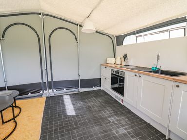 A kitchen with white cabinets a wooden countertop an oven a sink and appliances at The Salmon in Nantmel near Rhayader