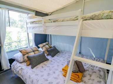 A bedroom with a white bunk bed a window and folded towels on the lower bed at The Salmon in Nantmel near Rhayader