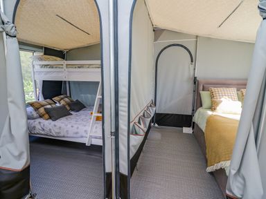Interior of a tent with bunk beds on the left and a double bed on the right at The Salmon in Nantmel near Rhayader
