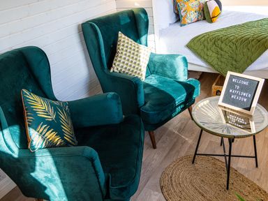 Two green armchairs with decorative pillows near a glass round table with a welcome sign at Veiko - Mayflower Meadow in Burshill near Brandesburton