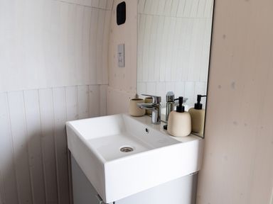 A bathroom sink with faucet soap dispenser and mirror on a wooden wall at Veiko - Mayflower Meadow Burshill near Brandesburton