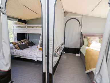 An interior view of a tent with a bunk bed on the left and a double bed on the right at The Otter in Nantmel near Rhayader