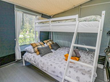 A bedroom with a bunk bed and pillows near a window at The Heron in Nantmel near Rhayader