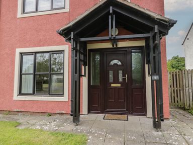 A front entrance with a dark wood door and black framed porch at 9 Eamont Park in Penrith