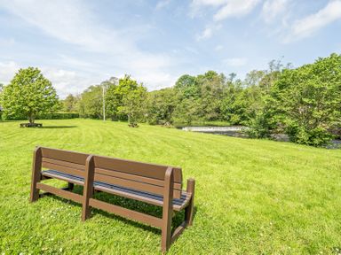 A park with a bench facing a river and trees at Jubilee Two Bedroom House Pet Free Baby Friendly Penrith