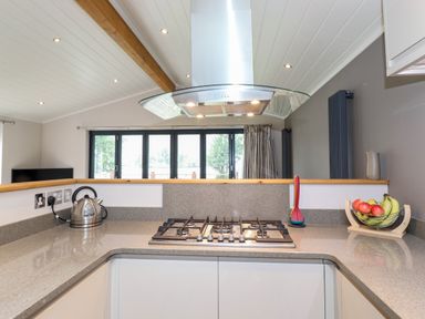 A kitchen countertop with a gas stove kettle and fruit bowl at Loubi's Lakeside Lodge M1 Fallbarrow Park near Bowness-On-Windermere